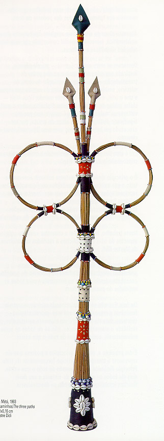 Escultura Opá Esin Métá (Os Três Caminhos), de Mestre Didi: haste de fibras trançadas com quatro anéis, faixas de contas vermelhas, brancas e pretas e base escura ornamentada com búzios.