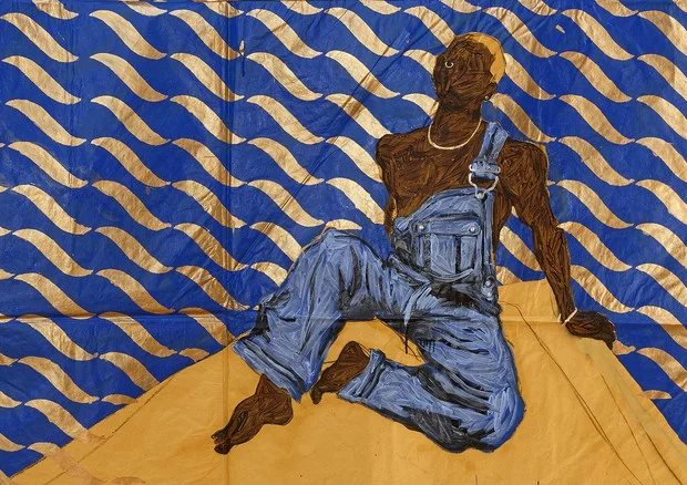 Pintura sobre papel pardo de Maxwell Alexandre: autorretrato de um homem negro de macacão jeans sentado diante de um fundo azul e dourado com padrões ondulados.